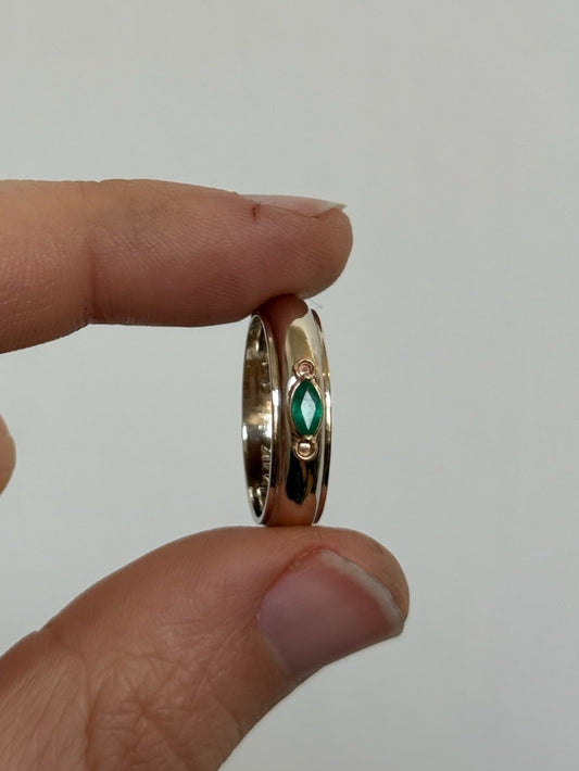 Gold ring with a green gemstone held 

